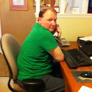 Hubby sitting at his desk in a green t-shirt