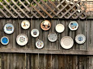 decorative plates hanging on the backyard fence